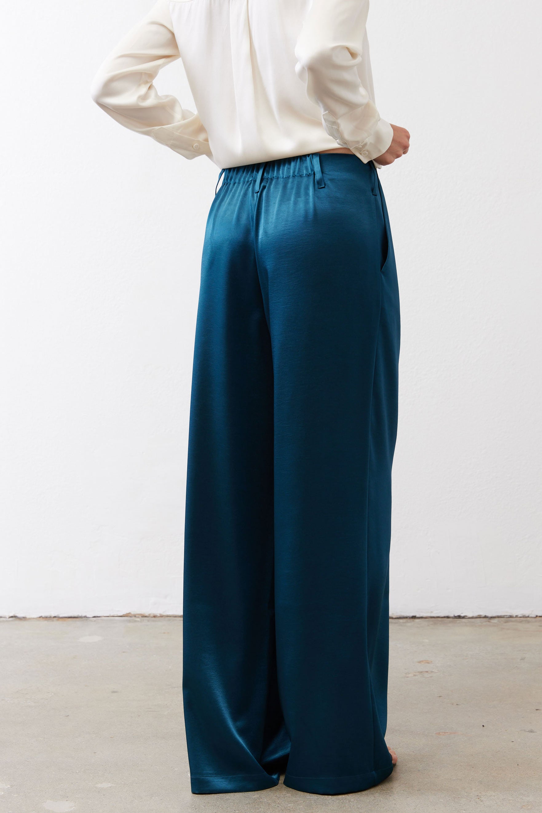 Deep teal wide-leg trousers with belt loops and relaxed straight legs