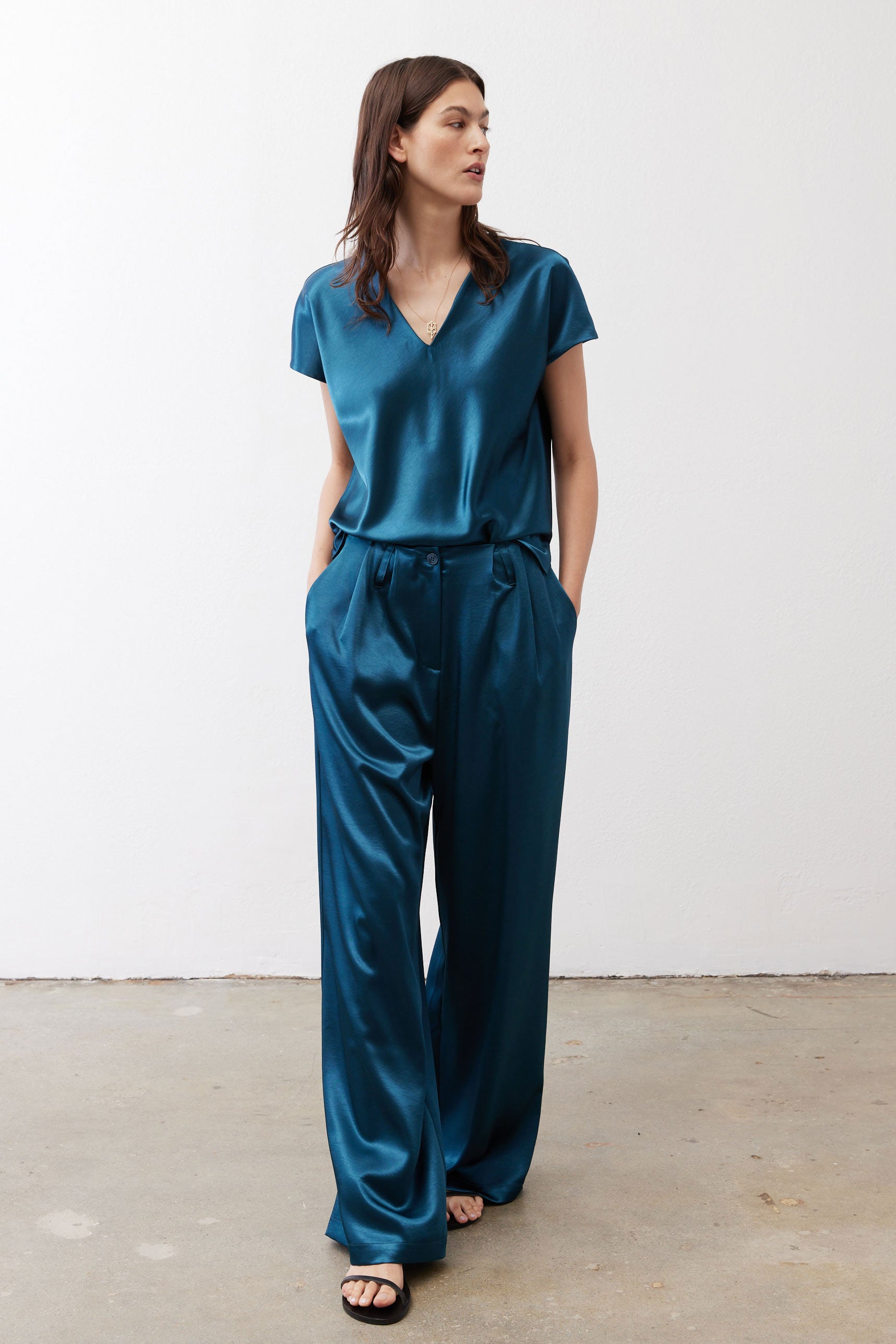 Deep teal wide-leg trousers with gathered waist and flowing leg opening