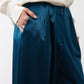Deep teal trouser waistband with belt loops and buttoned closure