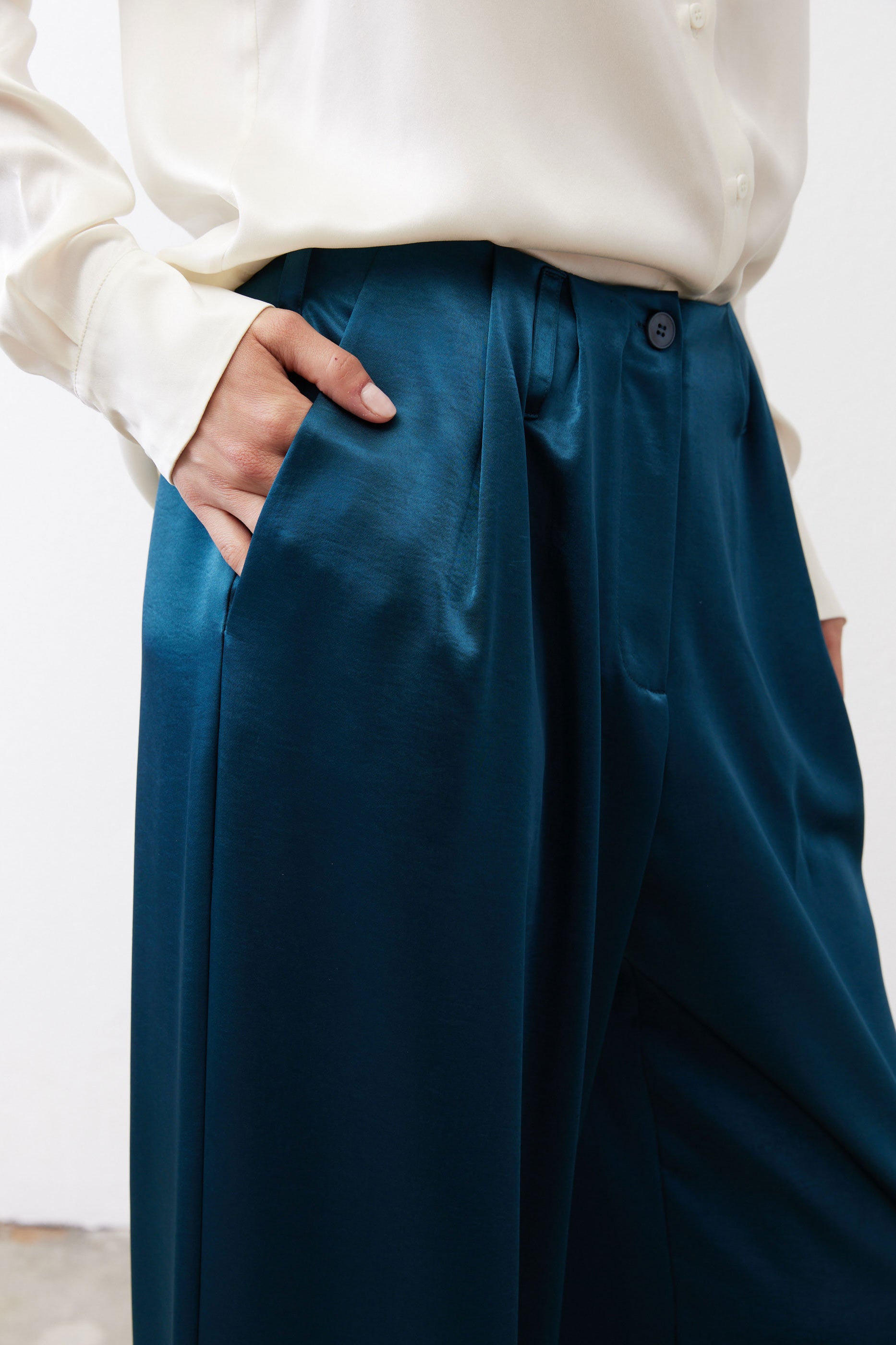 Deep teal trouser waistband with belt loops and buttoned closure