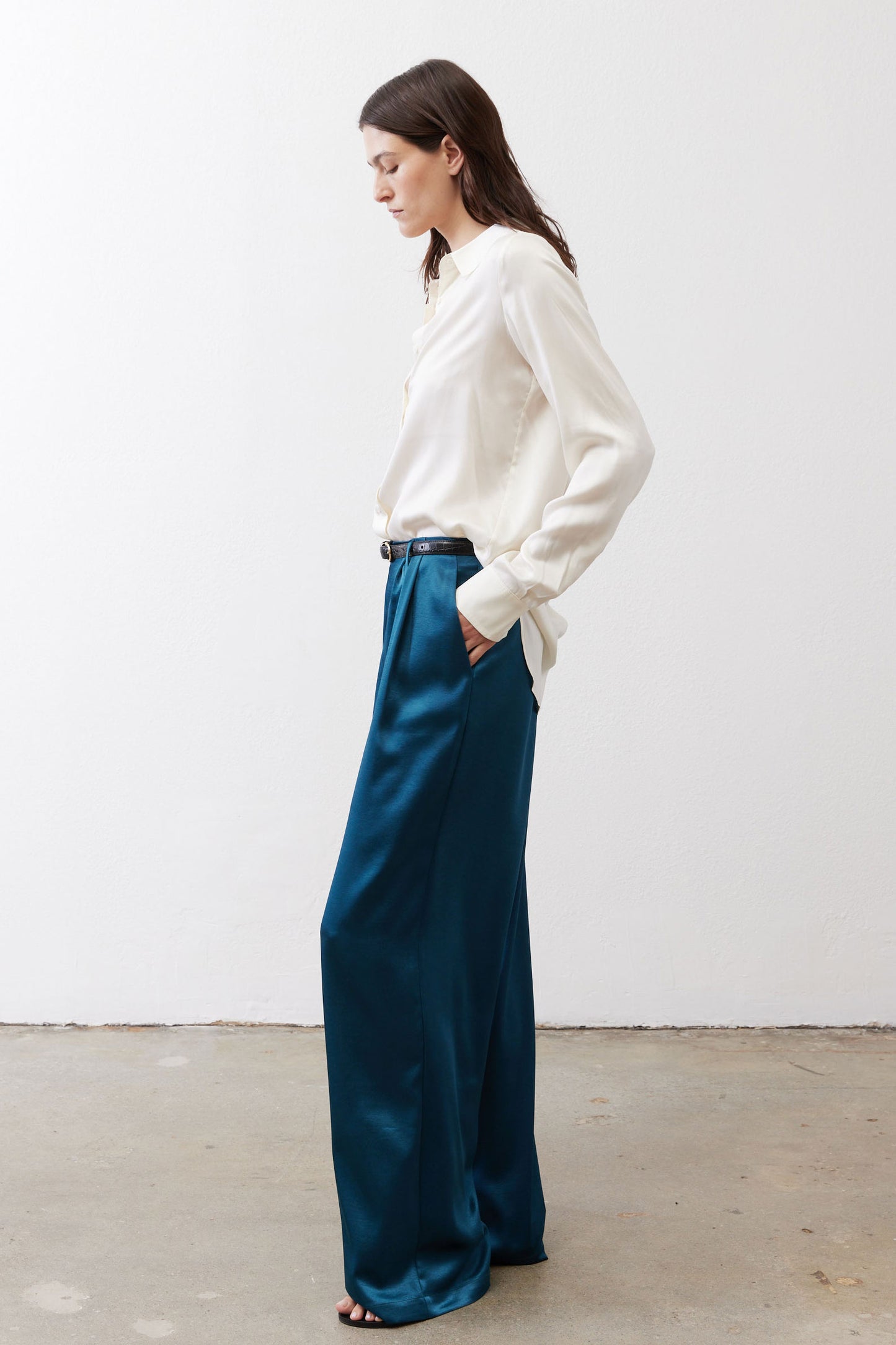 Deep teal wide-leg trousers with pleats, belt loops, and side pockets