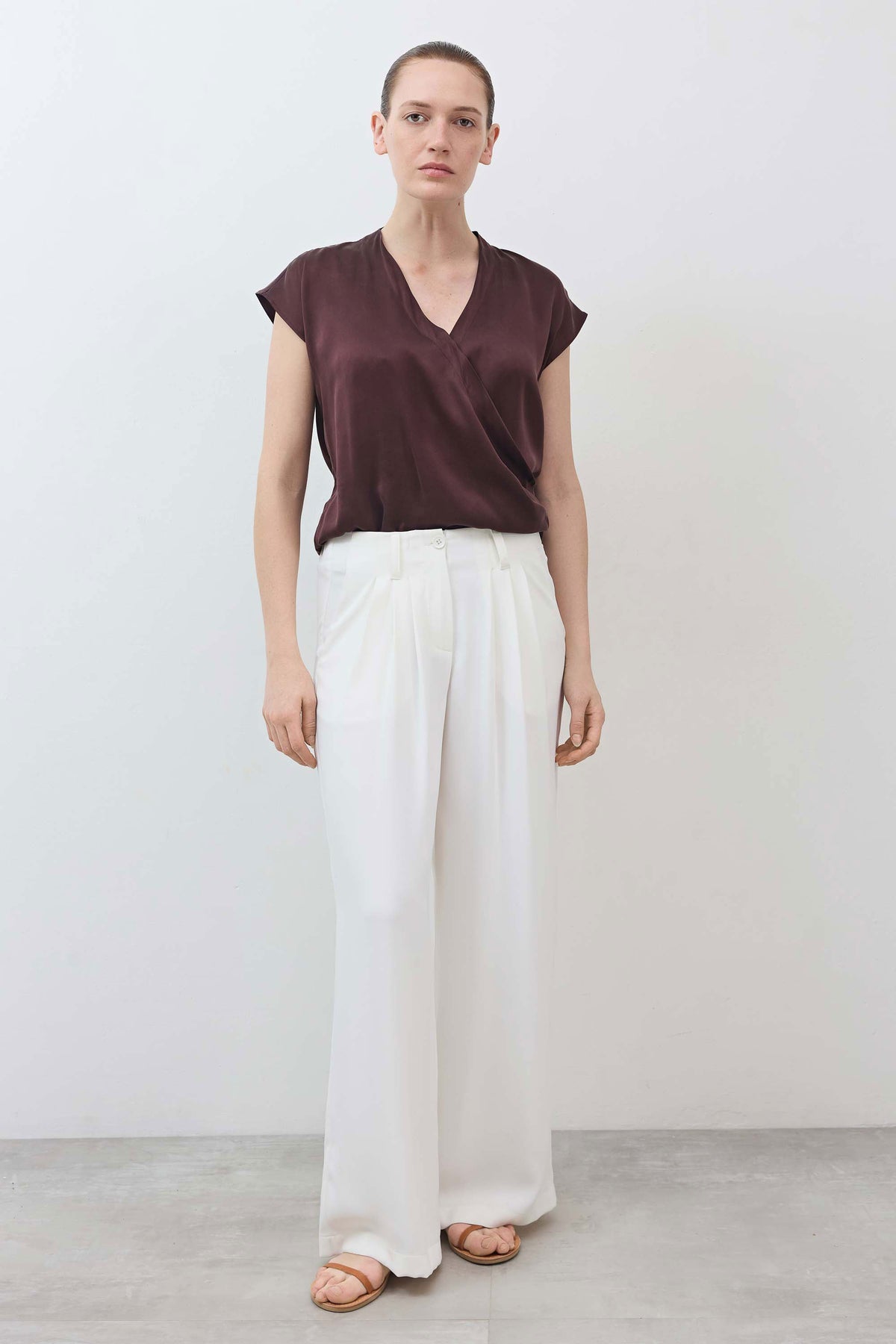 White wide-leg trousers with pleated front and flowy ankle-length hem