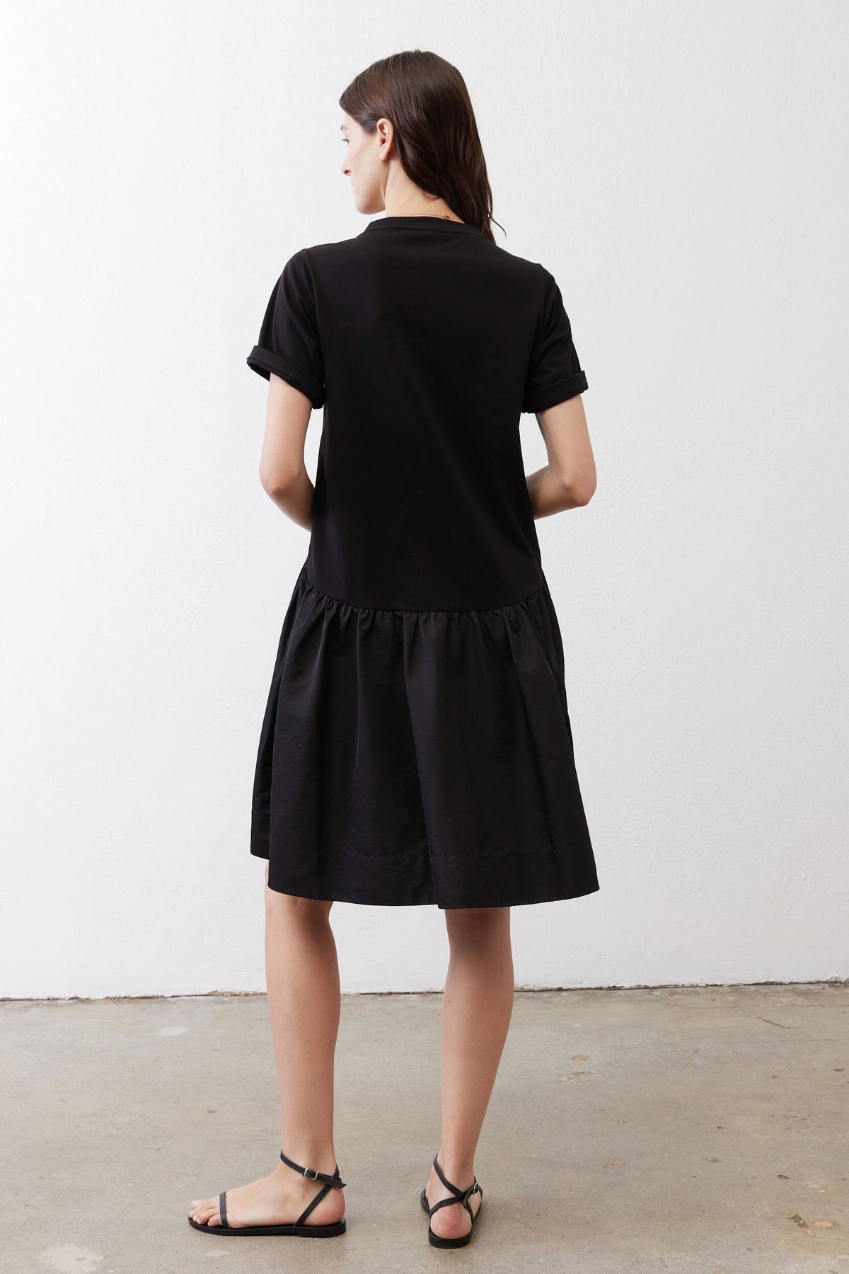 Black short-sleeve crewneck dress, back view, gathered waist and flared skirt