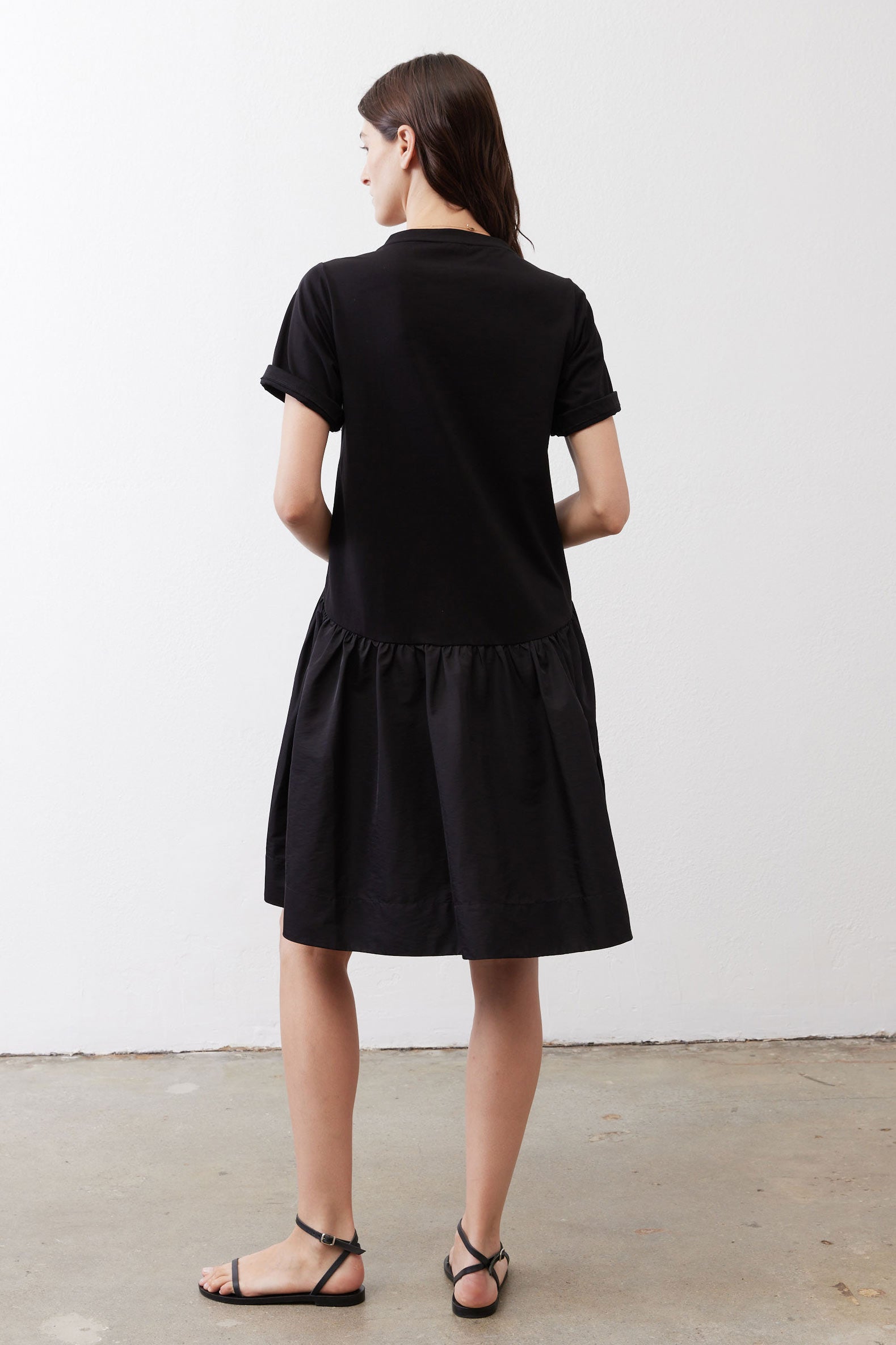 Black short-sleeve crewneck dress, back view, gathered waist and flared skirt