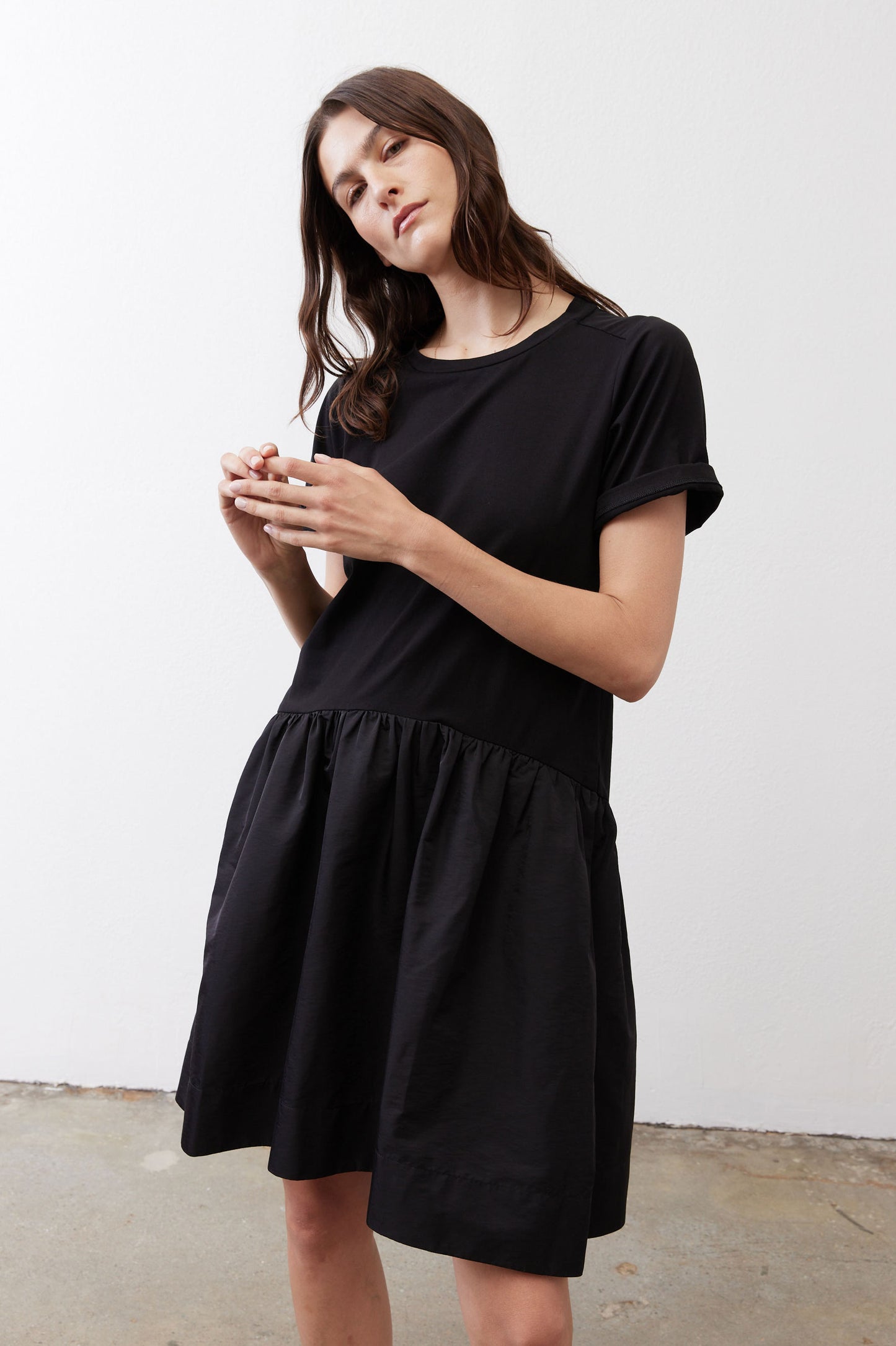 Black crewneck short-sleeve dress with tiered gathered skirt, front three-quarter view